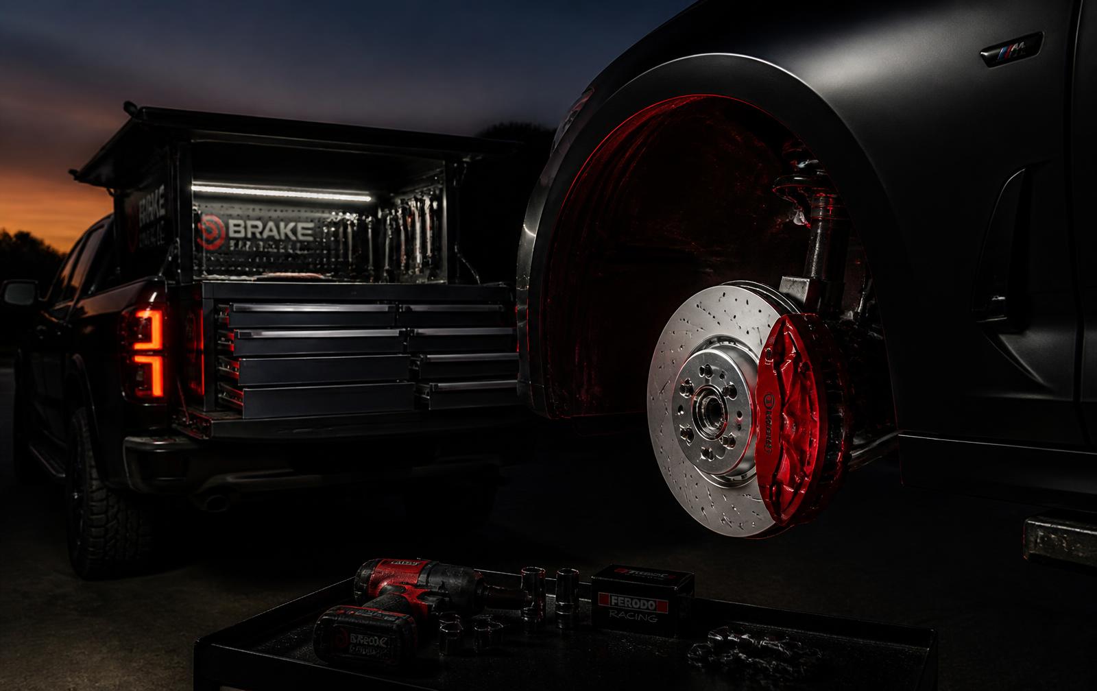 Mobile brake technician's service truck with a fresh rotor and red caliper at dusk